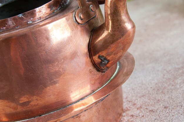 Photo old copper kettle on concrete background. copy space for text, food photography props.