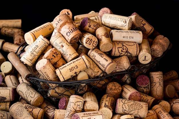 Old cork stoppers of French wines in a wire basket