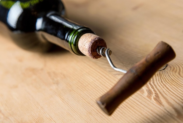 Old corkscrew opening a bottle of wine