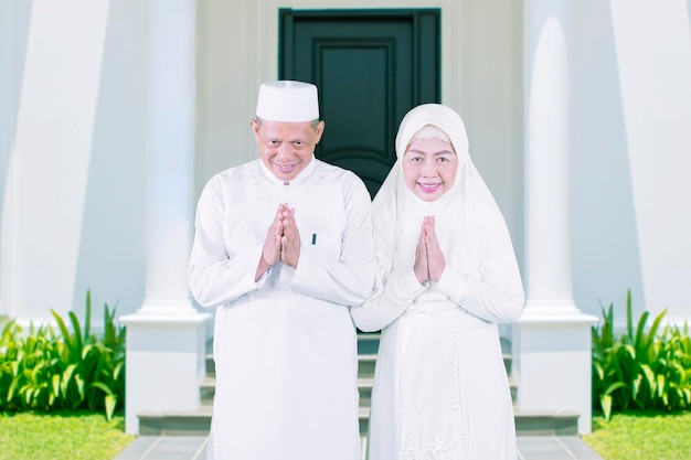 Old couple congratulating Eid in front of house