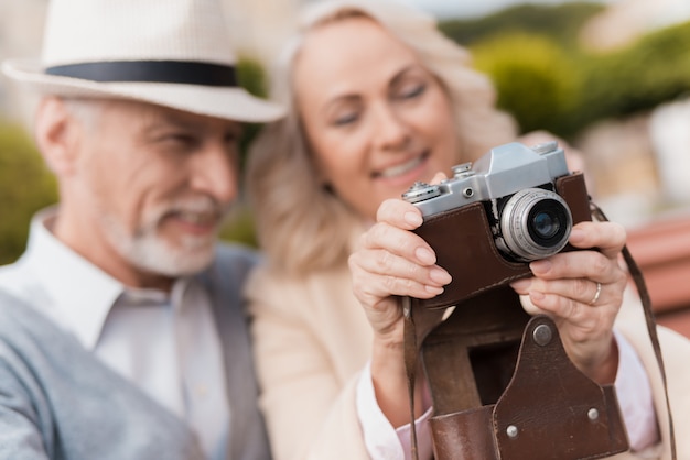 Vecchi abbracci di coppia. macchina fotografica d'annata della tenuta della donna.