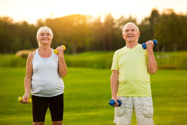 Photo old couple with dumbbells