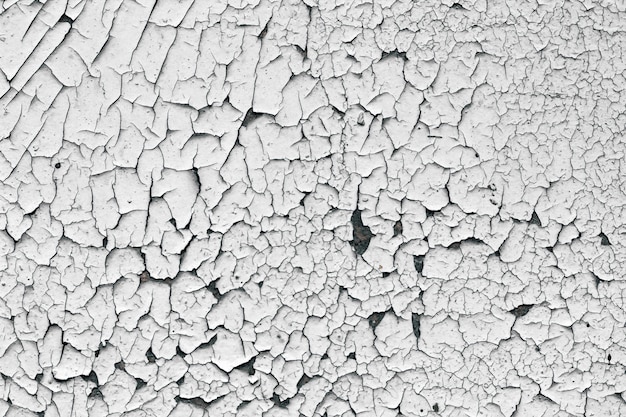 Old cracked paint texture. White paint on black surface.