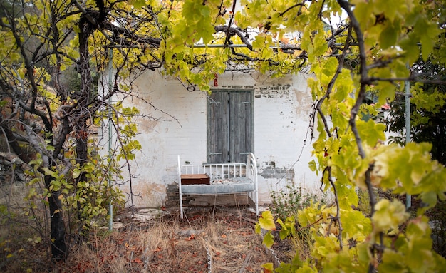 Old cradle against a wall of an abandoned house