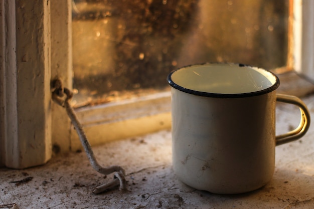 Photo an old cup on the windowsill