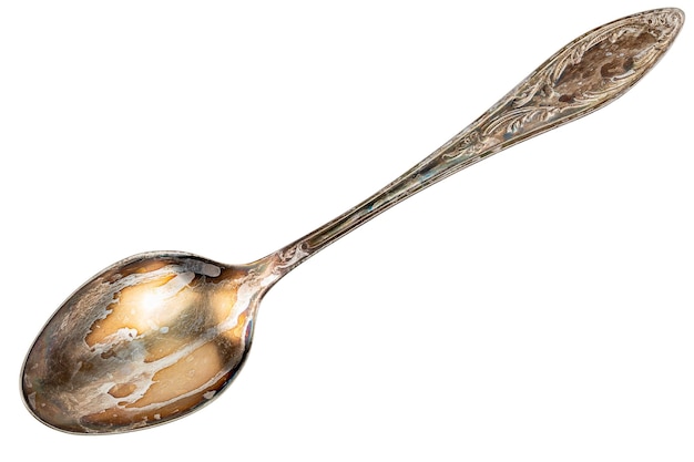 Photo old cupronickel spoon with visible oxidation layer isolated on white background