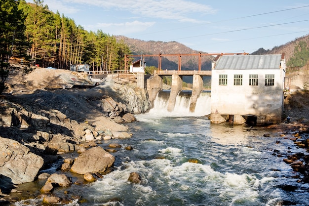 Old dam with flowing water on river hydroelectric power station hydro energy