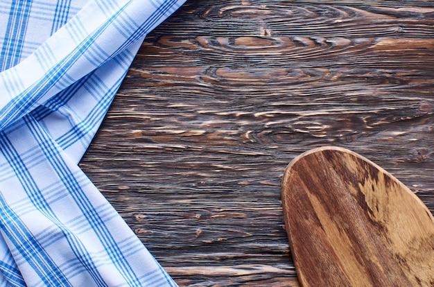 Old dark wooden background. Wooden table with blue kitchen towels