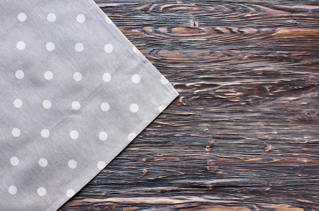 Old dark wooden background. Wooden table with grey kitchen towel