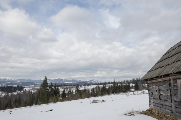 雪に覆われた山の古い老朽化した木造の建物