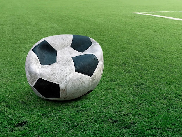 Old deflated soccer ball on soccer field