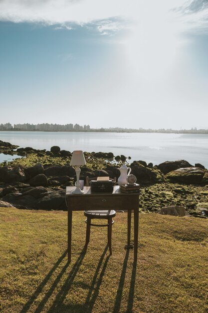 Old desk. Work table with a beautiful landscape. Desk with books, clock, lamp. Digital Nomad.