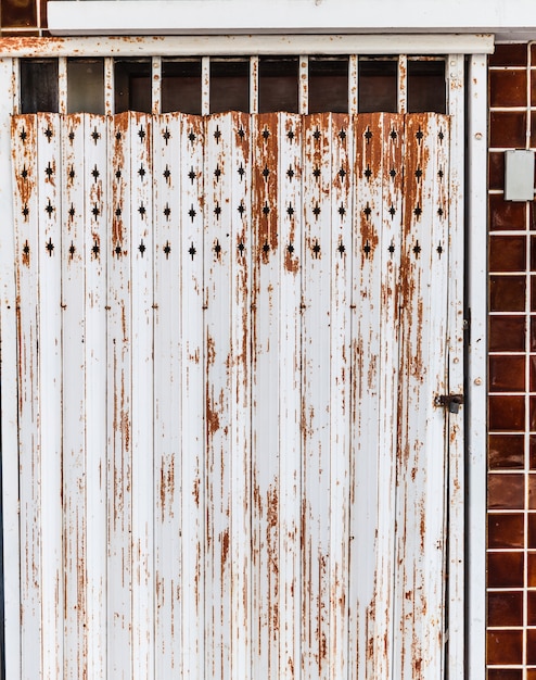 Old detailed aged vintage rusty brown textured steel alloy door stretch of store front