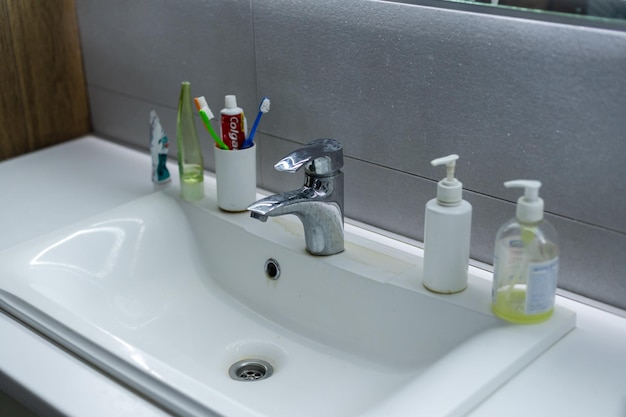 Old dirty washbasin with rust stains, limescale and soap stains in the bathroom with a faucet, water tap.