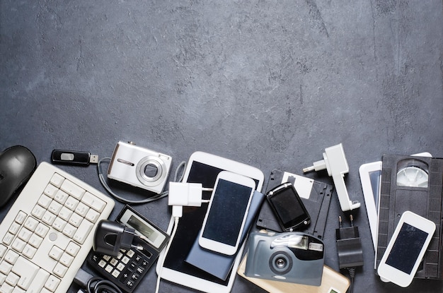 Old electronic devices on a dark background the concept of
recycling and disposal of electronic waste copy space