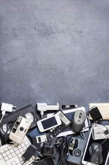 Old electronic devices on a dark background the concept of\
recycling and disposal of electronic waste copy space