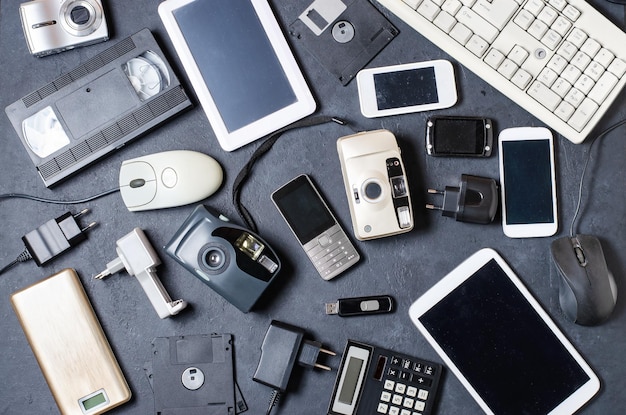 Old electronic devices on a dark background the concept of\
recycling and disposal of electronic waste