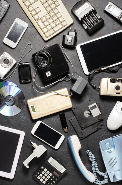 Old electronic devices on a dark background the concept of\
recycling and disposal of electronic waste