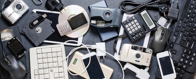 Old electronic devices on a dark background the concept of\
recycling and disposal of electronic waste