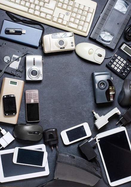 Old electronic devices on a dark background the concept of\
recycling and disposal of electronic waste