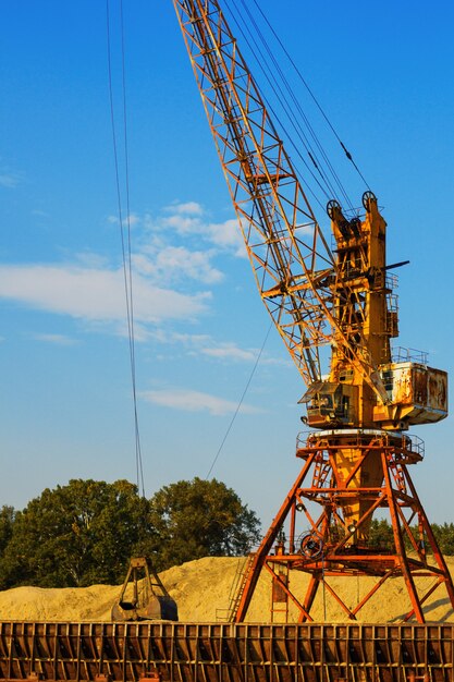 Old elevating crane offloads sand in the port