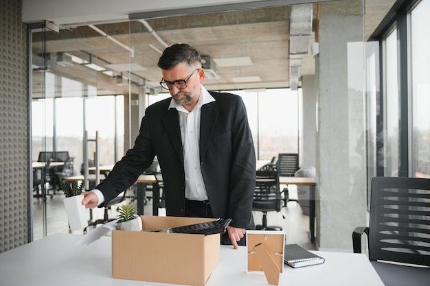 Old employee leaving office with the box full of belongings