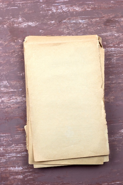 Old empty paper sheets top view brown shabby background