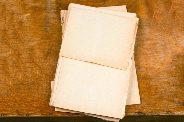 Old empty paper sheets top view wooden table