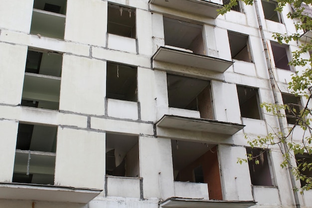 Old evicted and destroyed panel house for demolition with broken windows after resettlement. Recolat