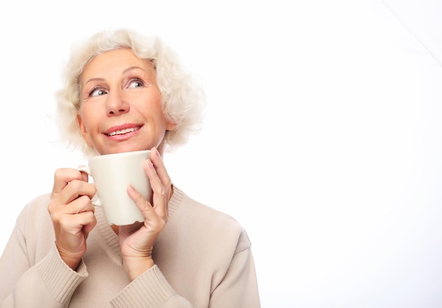 Old excited lady smiling laughing holding cup drinking coffee or tea