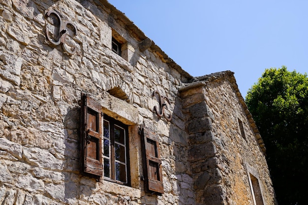 old farmhouse facade with typical stone wall classic wooden shutter window central France in Lozere