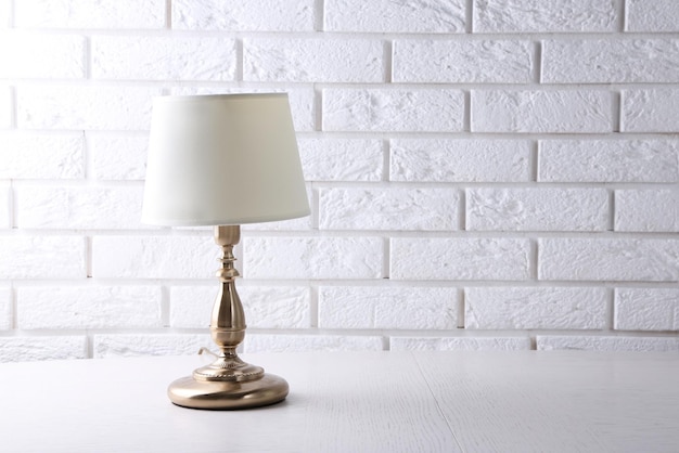 Old fashion table lamp on table on brick wall background