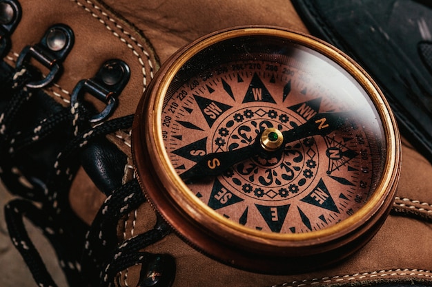 Old-fashioned compass on rustic wooden table