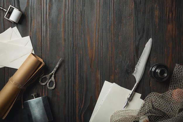 Piatto vecchio stile con lettere che scrivono accessori su fondo di legno scuro