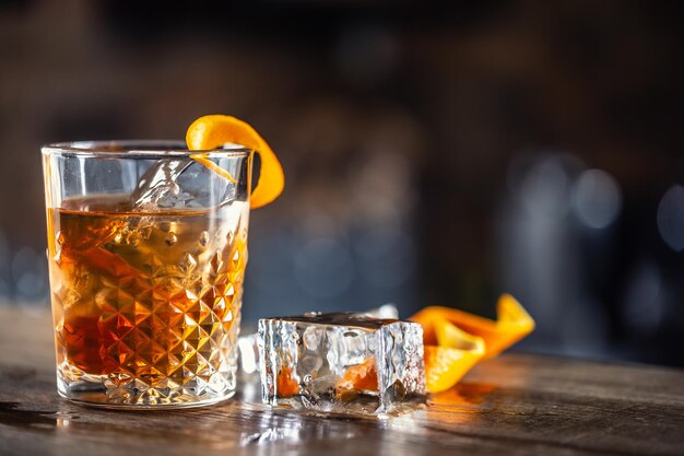 Photo old fashioned rum drink on ice with orange zest garnish