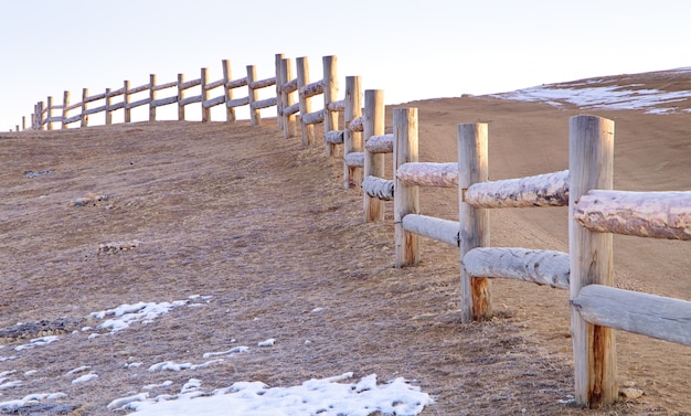 地面に雪と冬時間でログで作られた古いフェンス。オルホン島、ロシアのバイカル湖
