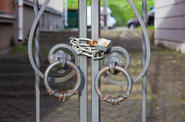 Old fence with lock and chain An old metal fence locked with a chain