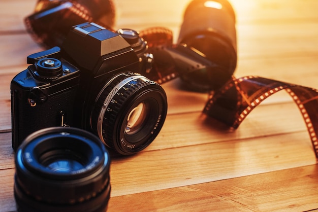 Old film camera and a roll of on wood