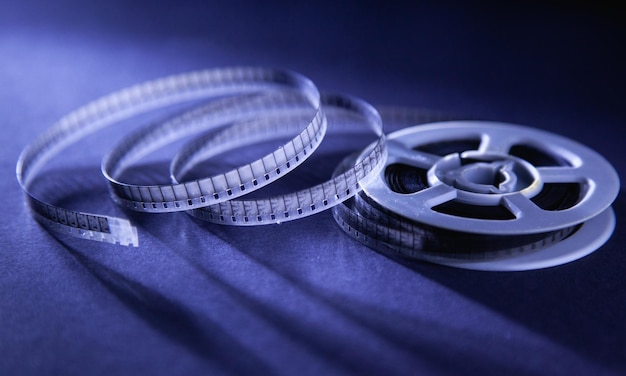 Foto una vecchia bobina di film si trova su uno sfondo blu con la parola film