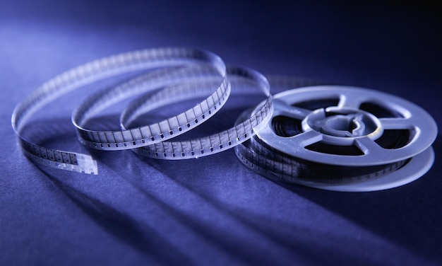 An old film reel sits on a blue background with the word movie