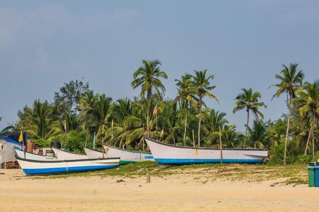 インドで青い空の背景に海の砂の中の古い漁船