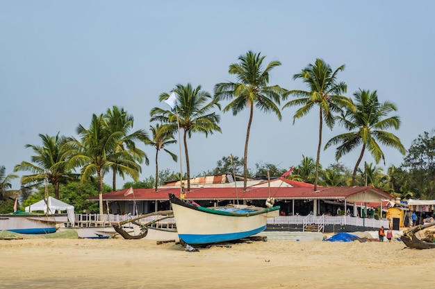 Old fishing boats in sand on ocean in India on blue sky background