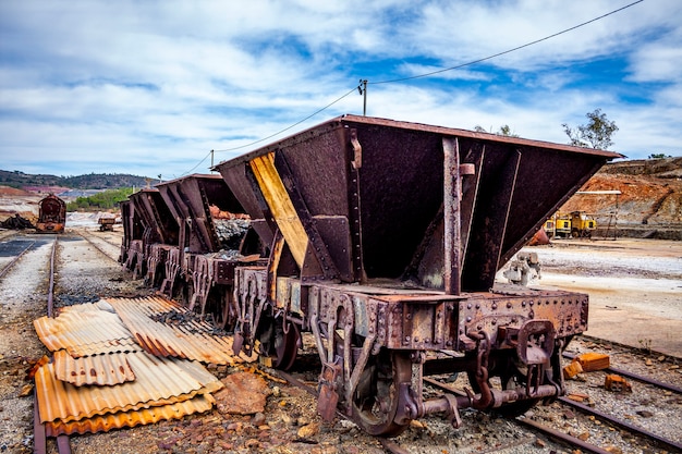 Old freight cars under a blue sky with clouds