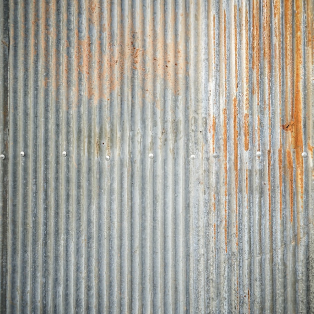 Vecchio muro in lamiera zincata con sfondo ruggine