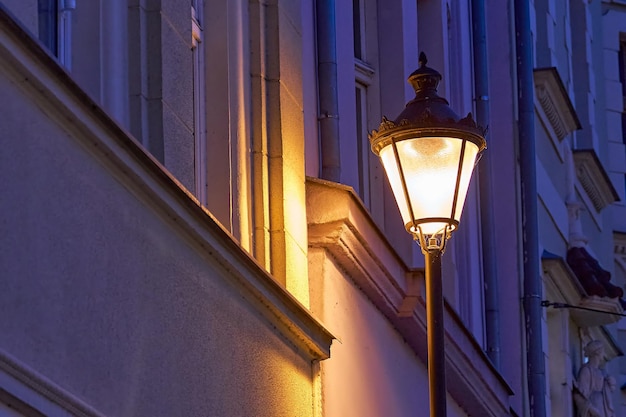 Foto una vecchia lanterna luminosa su uno sfondo di parete viola durante la notte