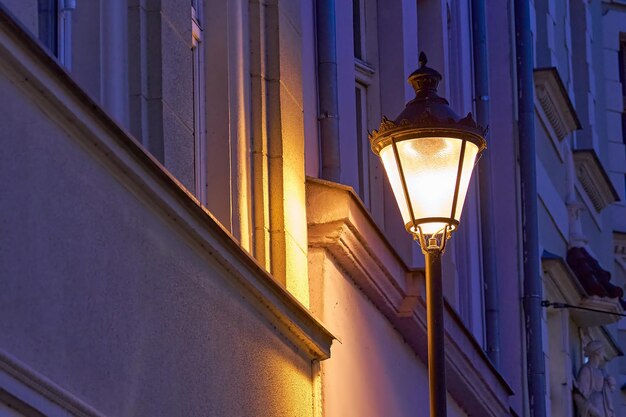 夜紫色の壁の背景の古い輝くランタン