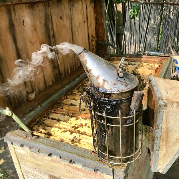 Old grandfather beekeeper works on his own rural apiary