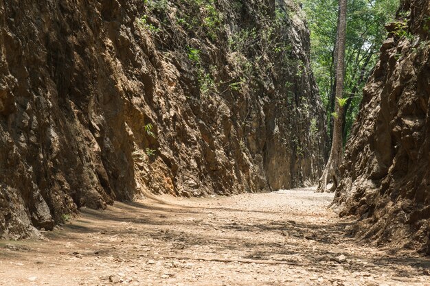 タイのカンチャナブリにあるヘルファイヤーパス記念碑を通る古い砂利道。ロッキー山脈。