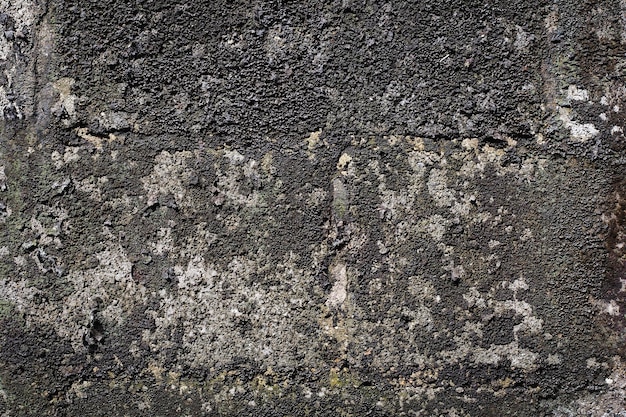 Vecchio muro di cemento grigio con crepe sulla superficie