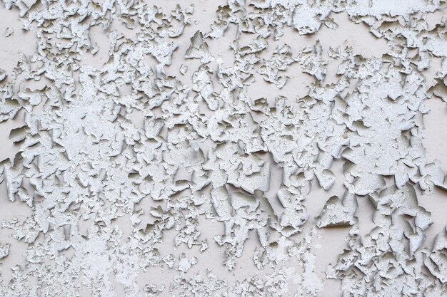 Old gray paint peeling from wall texture background Cracked paint on metallic background Grunge background